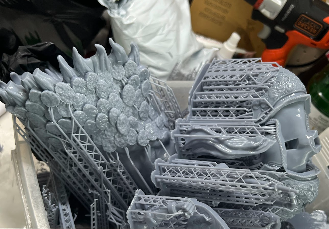 Detailed gray resin components surrounded by printing supports.
